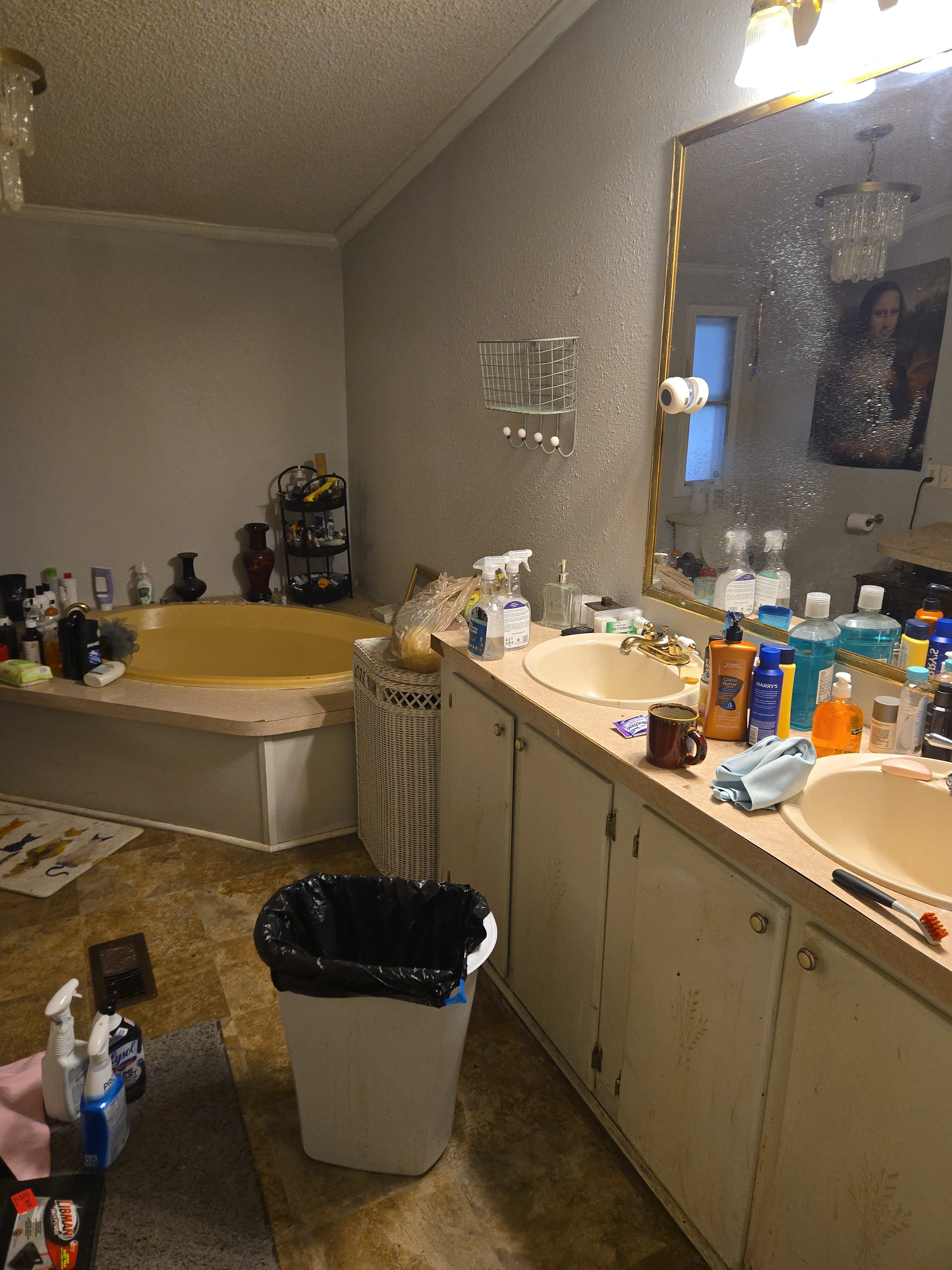 Primary bathroom before cleaning with a cluttered vanity and visible buildup