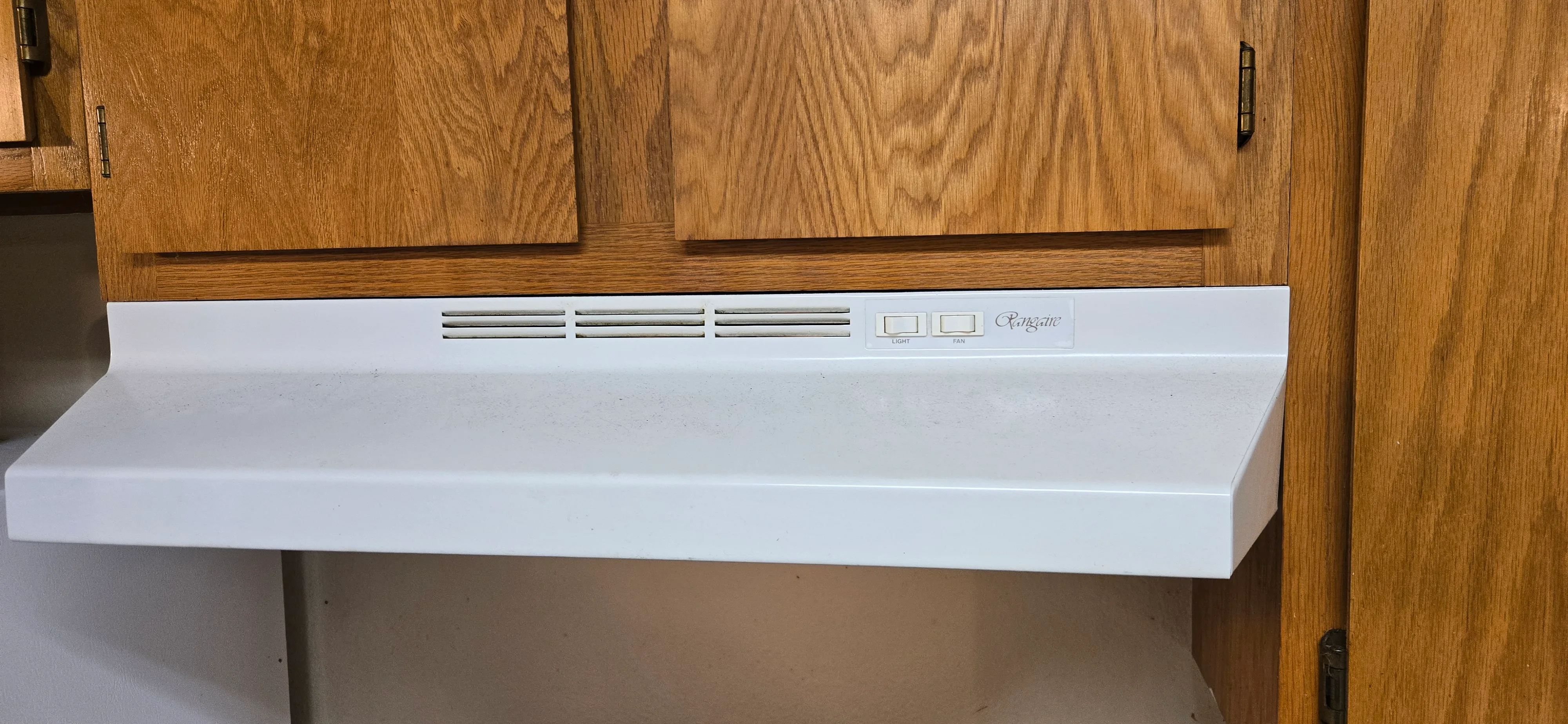 Range hood before cleaning with visible surface film and dust