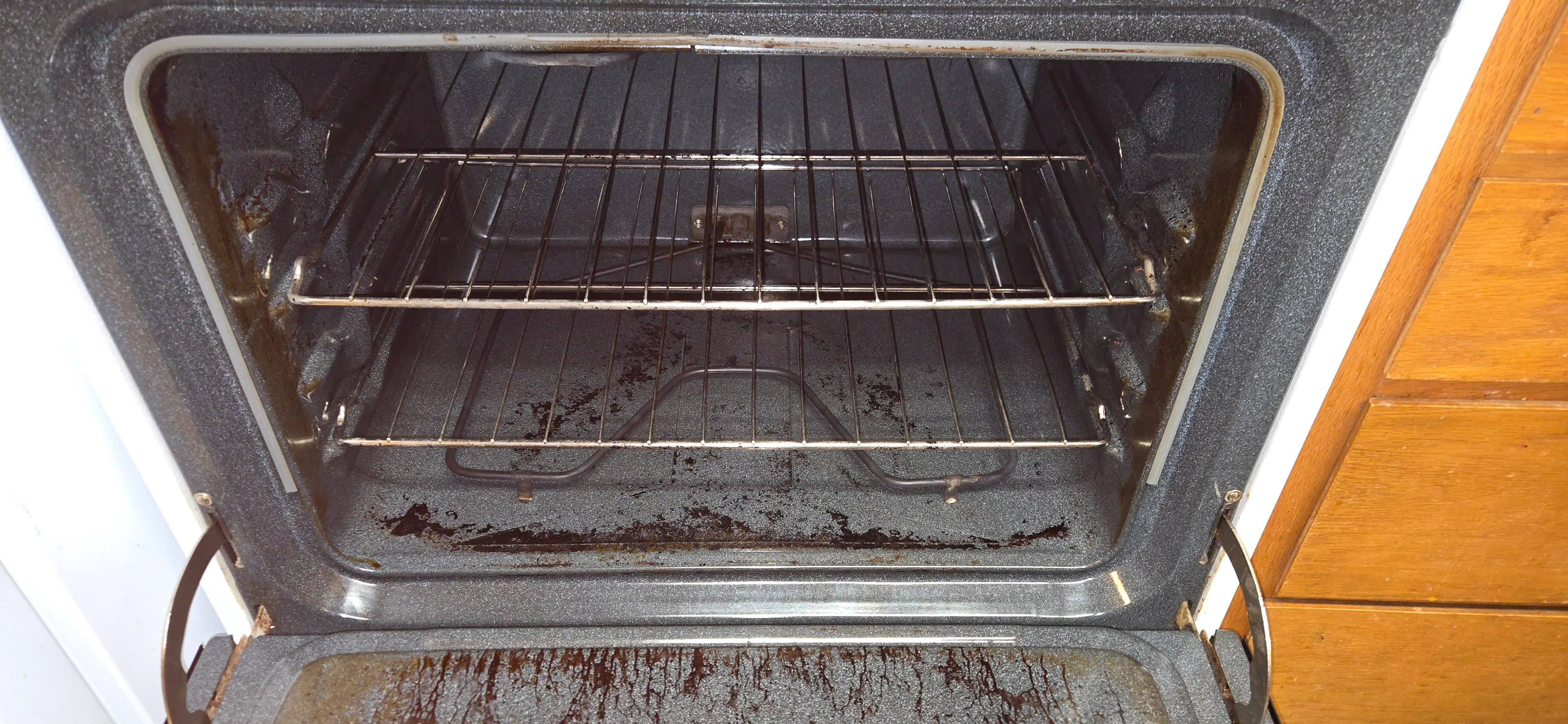 Oven interior after cleaning with major buildup removed and some set-in staining still visible